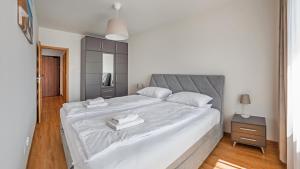 a bedroom with a large bed with two towels on it at Apartamenty Sun & Snow Baltea in Gdańsk