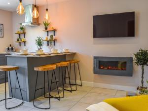 a bar in a living room with a fireplace at Yorkshire Cottage in Clayton West