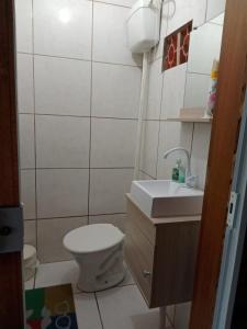 a small bathroom with a toilet and a sink at Casa 600mt da praia, 6km do Beto Carrero in Navegantes