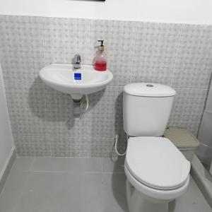 a white bathroom with a toilet and a sink at CASA TORO in Puerto Triunfo