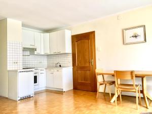 a kitchen with white appliances and a table and chairs at Apartman Jana by Wörthersee in Raunach