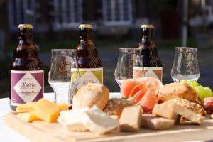 two bottles of beer and a plate of cheese and wine glasses at Abdij Hotel Rolduc in Kerkrade