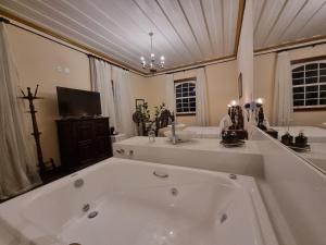 a large white bath tub in a bathroom at Teatro Hotel Boutique in Ouro Preto