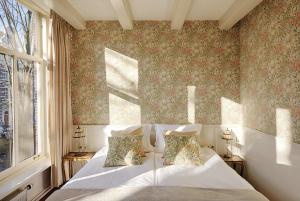 um quarto com uma cama branca e uma janela em 't Hotel em Amsterdã