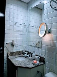 a bathroom with a sink and a mirror at Flat LakeSide -Vista para o lago C17 in Brasilia
