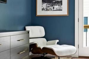 Mountain Retreat Haven-Hot Tub-Game Room في McGaheysville: غرفة زرقاء مع كرسي أبيض ومقعد