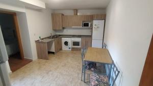 a kitchen with wooden cabinets and a white refrigerator at Casa Marcelinas in Samper del Salz