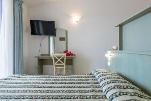 ein Schlafzimmer mit einem Bett und einem Fernseher an der Wand in der Unterkunft Palm Village in Villasimius + 85 Fotos