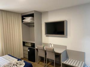 a room with a desk and a tv on the wall at Real Palace Hotel in Rio de Janeiro