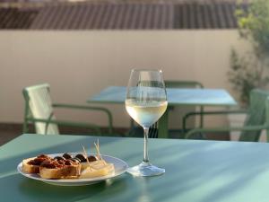 una copa de vino blanco junto a un plato de comida en Re Sale Boutique Hotel, en Trapani