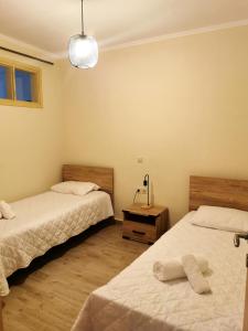 a bedroom with two beds and a lamp and a table at Zante Ionian City House in Zakynthos Town
