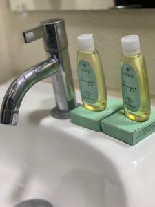 two bottles of soap sitting on a bathroom sink at Hotel La Capilla - Suites & Apartments San Benito in San Salvador