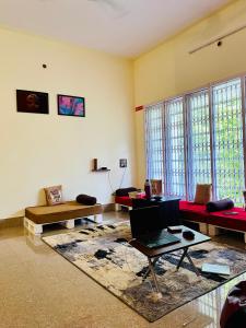 a living room with couches and a laptop on a table at Crossroads Hostel 1980 in Mysore