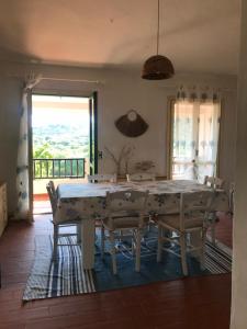comedor con mesa blanca y sillas en Residence Pinnetta Cala Bitta, en Baja Sardinia