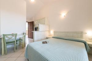 a bedroom with a large bed with a blue blanket at Palm Village in Villasimius +79 photos
