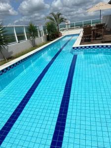 a large swimming pool with blue tiles on a building at Apartamento West Flat in Mossoró