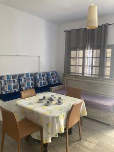 La Marsa Maison avec jardin, terrasse parking Wifi Illimité في المرسى: غرفة طعام مع طاولة مع كراسي وقطعة قماش.