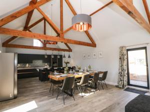 a dining room with a large wooden table and chairs at Langley Barn in Ashbourne