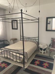 sypialnia z czarnym łóżkiem z baldachimem i dywanem w obiekcie La Marsa Maison avec jardin, terrasse parking Wifi Illimité w mieście La Marsa