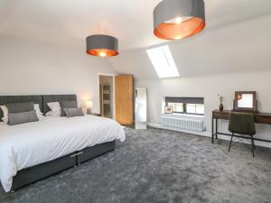 a bedroom with a large bed and a desk at Langley Barn in Ashbourne