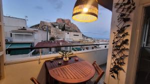een tafel en stoelen op een balkon met uitzicht bij Corazón de Alicante con vistas al mar y al castillo in Alicante