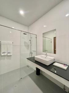 y baño con lavabo y ducha acristalada. en Air Diamond Hotel en Ban Nong Khong