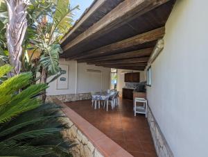 a patio with a table and a kitchen in a house at Villa Lucia Fontane Bianche in Fontane Bianche