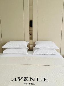 two pillows on a bed in a hotel room at Hotel AVENUE in Ravda