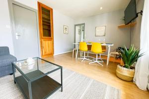uma sala de estar com uma mesa e cadeiras amarelas em The Palmeraie Garden Parking #DF em La Tronche