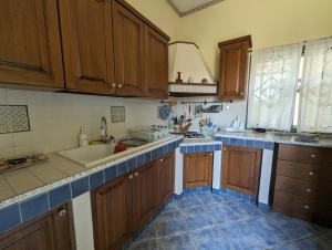 a kitchen with wooden cabinets and blue tile floors at Villa Lucia Fontane Bianche in Fontane Bianche +14 photos