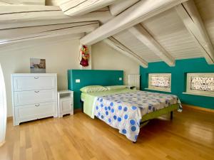 een slaapkamer met een bed, groene muren en houten vloeren bij loft39 Roero in Montà