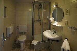a bathroom with a toilet and a sink and a shower at Abdij Hotel Rolduc in Kerkrade