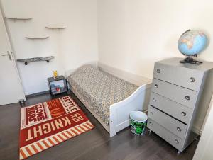 Dormitorio pequeño con cama, cómoda y alfombra en Maison BALARUC LES BAINS, en Balaruc-les-Bains
