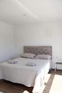 sypialnia z białym łóżkiem z 2 poduszkami w obiekcie Apartman Karmen w mieście Brodarica