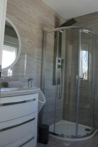 W łazience znajduje się prysznic i umywalka. w obiekcie Apartman Karmen w mieście Brodarica