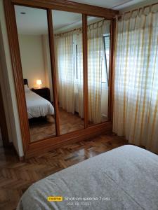 einen Spiegel in einem Zimmer mit einem Bett und einem Schlafzimmer in der Unterkunft AGUAVIVA in Argüero