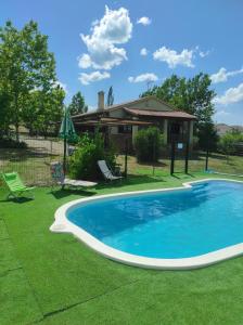 una piscina in un cortile con una casa di La casa de la parcela a Piedrahita