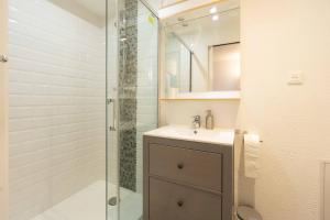 Un baño con lavabo y ducha de cristal. en Chalet Belamy Studio 1, en Courchevel