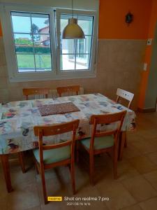 mesa de comedor y sillas con mesa y ventanas en AGUAVIVA, en Argüero