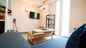 uma sala de estar com uma mesa de centro e uma televisão em Studio Apartment Massena Nice! Free Breakfast! em Nice