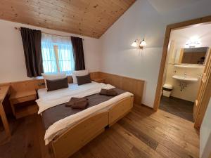 een slaapkamer met een groot bed en een wastafel bij Gasthaus Bad Siess in Longostagno