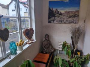 a statue sitting on a bench in a room with windows at Historischer Hof, einladend für Mensch und Tier. in Schenklengsfeld