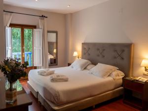 sypialnia z dużym łóżkiem i dwoma ręcznikami na nim w obiekcie Hotel Rural Spa Don Juan de Austria w mieście Jarandilla de la Vera