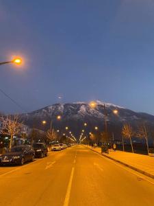 an empty street with a mountain in the background at Welcome home in Kukës