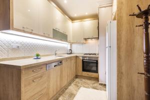 a kitchen with wooden cabinets and a white refrigerator at Modern and Central Flat in Nisantasi in Istanbul