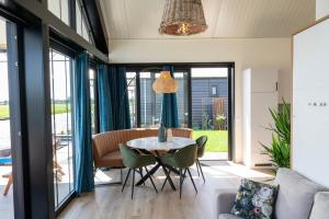 een eetkamer met een tafel en stoelen bij 4 to 6 persons waterfront villa in Roelofarendsveen