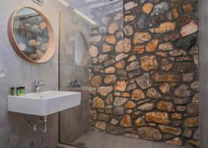 a bathroom with a sink and a stone wall at Ktima Faki in Litochoro