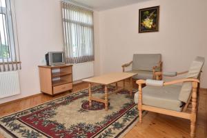 a living room with a table and two chairs and a tv at Grand Village in İsmayıllı