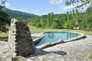 una piscina con una pared de piedra alrededor en Grand Village, en İsmayıllı