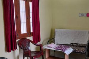 une chambre avec une chaise, une table et une fenêtre dans l'établissement A Sweet home Homestay Second Floor, à Palni